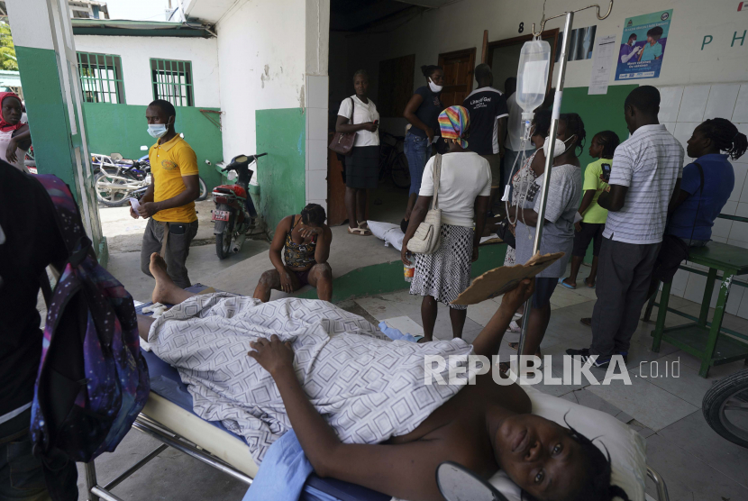 Seseorang yang terluka akibat gempa berbaring di atas tandu sementara orang lain yang terluka dalam kecelakaan mobil duduk di belakang, di Rumah Sakit Umum di Les Cayes, Haiti, Rabu, 18 Agustus 2021. Kekurangan bahan bakar di Haiti dapat membahayakan nyawa ratusan pasien di RS.