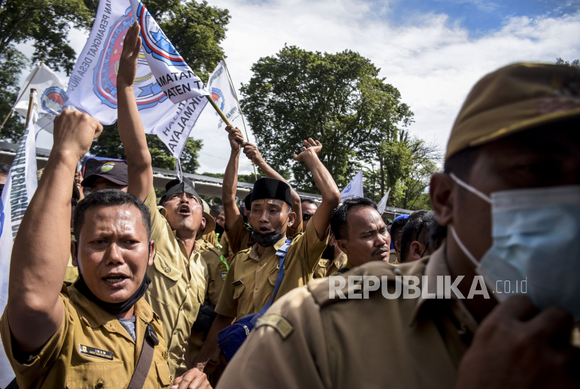 Sejumlah perangkat desa yang tergabung dalam Persatuan Perangkat Desa Indonesia (PPDI) berunjuk rasa di depan Gedung Sate, Jalan Diponegoro, Kota Bandung, Senin (6/12). Dalam unjuk rasa tersebut mereka mendesak agar pemerintah dapat memberikan penegasan terhadap pemberhentian perangkat desa non prosedural pasca Pilkades serentak, meminta penambahan tunjangan aparatur desa melalui bantuan keuangan Pemerintah Provinsi Jawa Barat dan mendorong terbitnya Permendagri tentang Nomor Induk Perangkat Desa (NIPD). Foto: Republika/Abdan Syakura