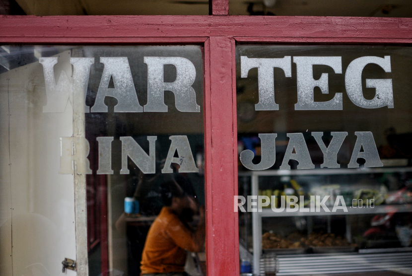 Pengunjung menyantap makanan di salah satu rumah makan Warteg di Jakarta.