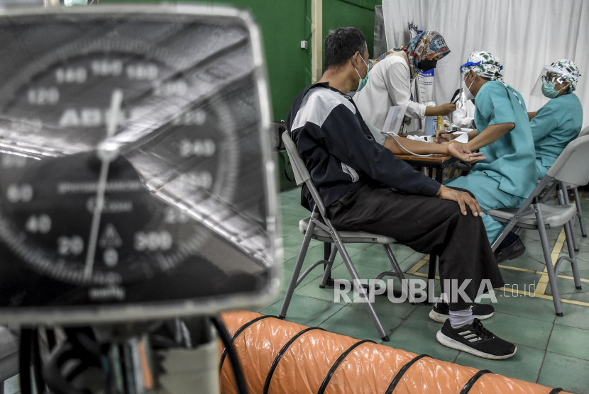 Seorang guru menjalani pemeriksaan kesehatan sebelum disuntik vaksin Covid-19 di Aula RS Advent Bandung, Jalan Cihampelas, Kota Bandung, Rabu (21/4). Kepala Dinas Pendidikan Jawa Barat Dedi Supandi menyatakan, saat ini vaksinasi bagi guru dan tenaga pendidik di Jawa Barat sudah mencapai 65 persen dan pihaknya terus melakukan upaya percepatan vaksinasi sebagai bentuk persiapan pembelajaran tatap muka (PTM) yang rencananya akan digelar pada Juli 2021 mendatang. Foto: Republika/Abdan Syakura