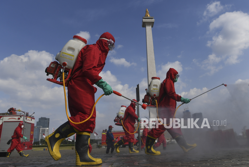 Petugas Pemadam Kebakaran menyemprotkan cairan disinfektan di kawasan Monumen Nasional (Monas), Jakarta, Rabu (17/6/2020). Penyemprotan cairan disinfektan untuk mencegah penyebaran COVID-19 di kawasan Monas yang akan dibuka kembali pada 20 Juni 2020