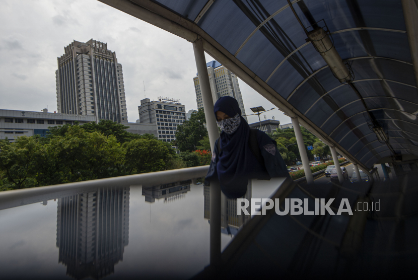 Warga melintas di jembatan penyeberangan orang (JPO) di depan Kantor Direktorat Jenderal Pajak Kementerian Keuangan, Jalan Gatot Subroto, Jakarta, Selasa (24/11). Kementerian Keuangan (Kemenkeu) memprediksi, tren pemulihan ekonomi yang sudah terjadi pada kuartal keempat akan terus berlanjut pada tahun ini. 