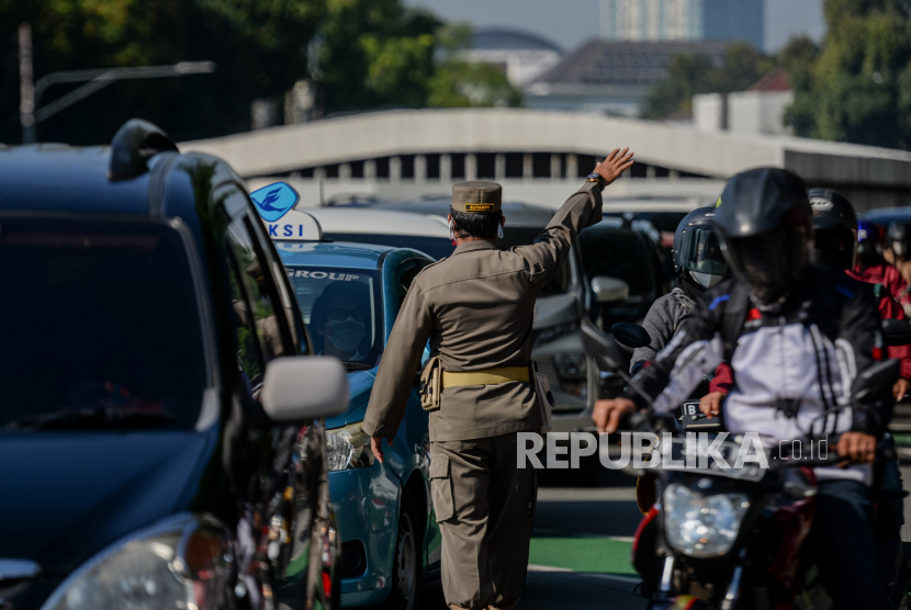 Petugas gabungan melakukan operasi ganjil genap di kawasan Bundaran Senanyan, Jakarta, Kamis (12/8).