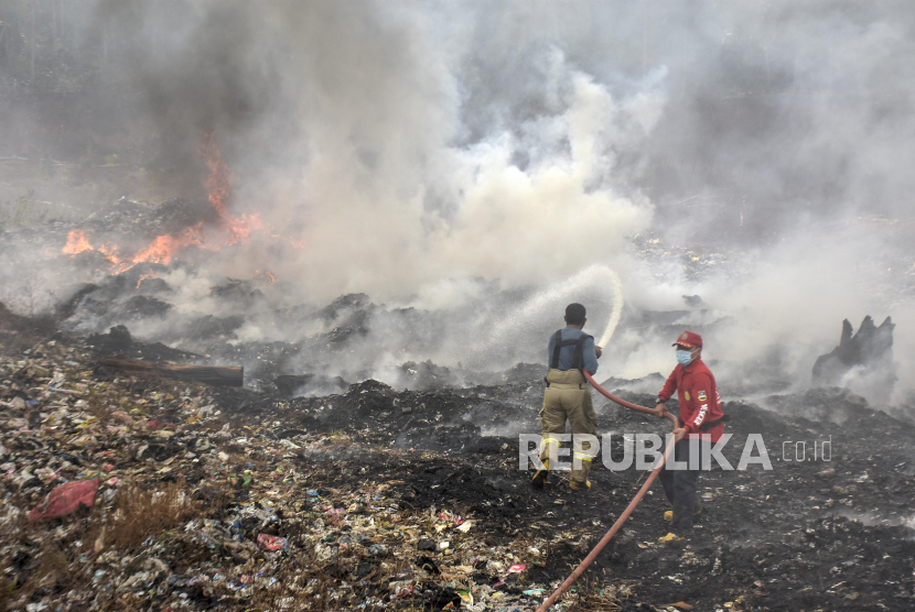 Petugas pemadam kebakaran (damkar) menyemprotkan air untuk memadamkan api di area tumpukan sampah TPA Sarimukti, Cipatat, Kabupaten Bandung Barat, Jawa Barat, Rabu (23/8/2023).