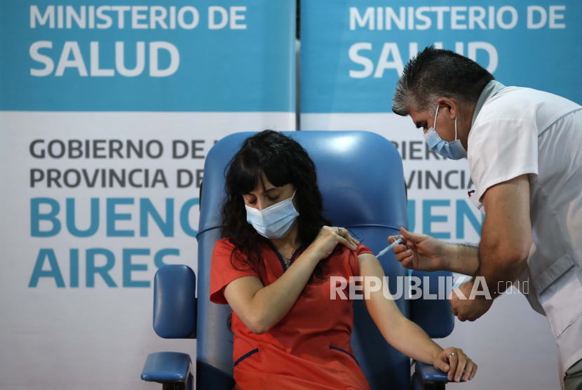 Perawat Gustavo Rodriguez memberikan suntikan vaksin Sputnik V Rusia untuk Covid-19 kepada Dr. Estefania Zevrnja di Rumah Sakit Dr. Pedro Fiorito di Avellaneda, Argentina, Selasa, 29 Desember 2020.