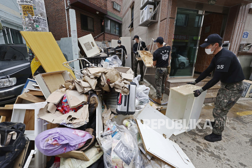  Tentara membawa puing-puing setelah air banjir mengalir dari rumah-rumah yang terendam setelah hujan lebat di Seoul, Korea Selatan. (Ilustrasi)