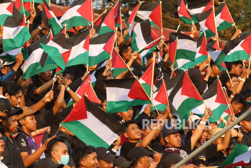 Supporters wave Palestinian flags during the Persik Kediri Liga 1 competition match against Persebaya Surabaya at the Brawijaya Stadium, Kediri City, East Java, Friday (27/10/2023). 
