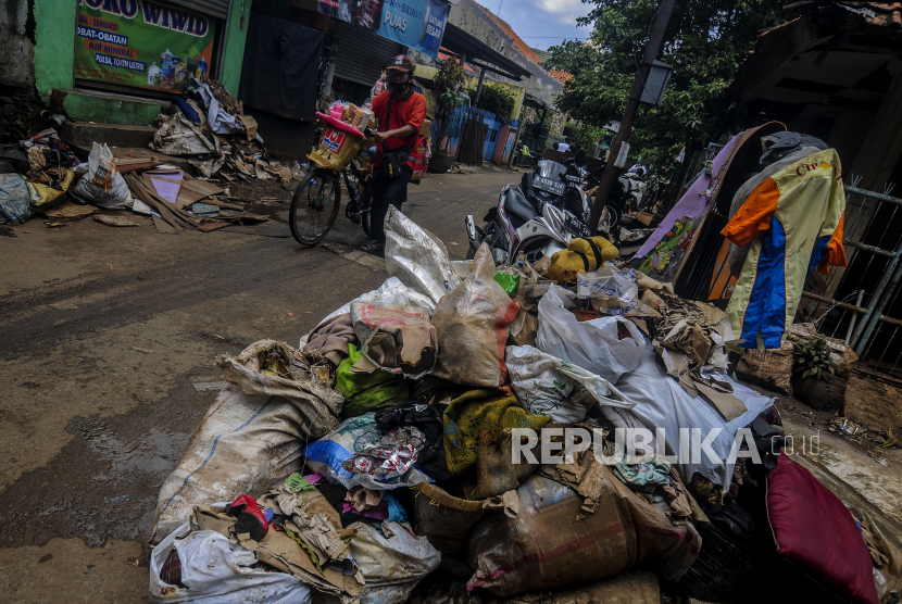 Pedagang melintas di dekat tumpukan sampah (ilustrasi)