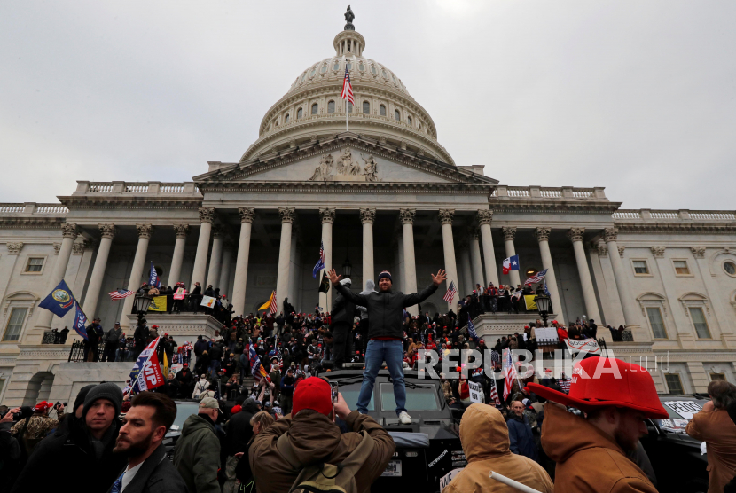 Massa pendukung President Donald Trump menduduki gedung Capitol selama protes menentang Kongres yang akan mengesahkan kemenangan Joe Biden, Rabu (6/1). 