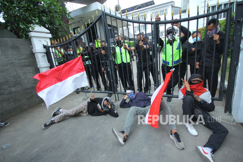 Sejumlah mahasiswa tiduran di depan gerbang dalam aksi mahasiswa menolak UU Omnibus Law, di depan Gedung DPRD Jawa Barat, Jalan Dipenogoro, Kota Bandung, Rabu (7/10). Mereka mendesak pemerintah mencabut UU Cipta Kerja yang telah disahkan. Mahsiswa menilai UU ini hanya berorientasi pada keuntungan pengusaha semata.