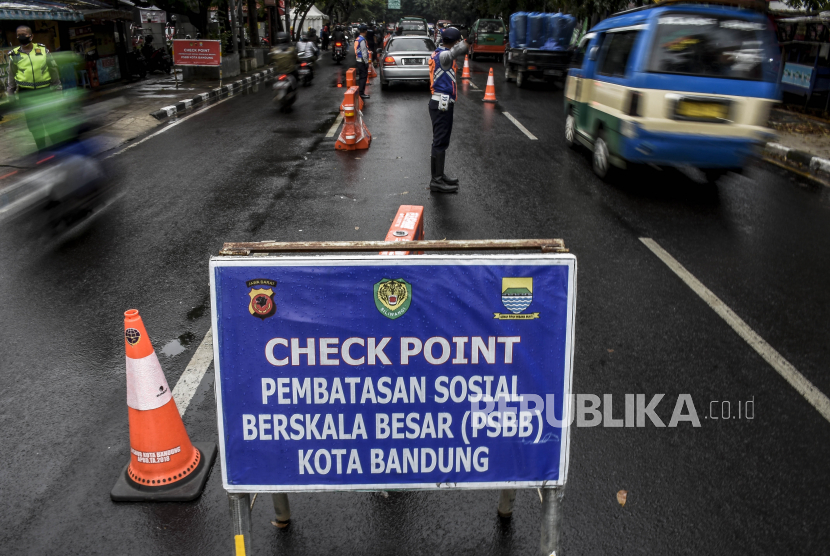 Petugas gabungan mengatur arus lalu lintas di pos pemeriksaan Pembatasan Sosial Berskala Besar (PSBB) Bandung