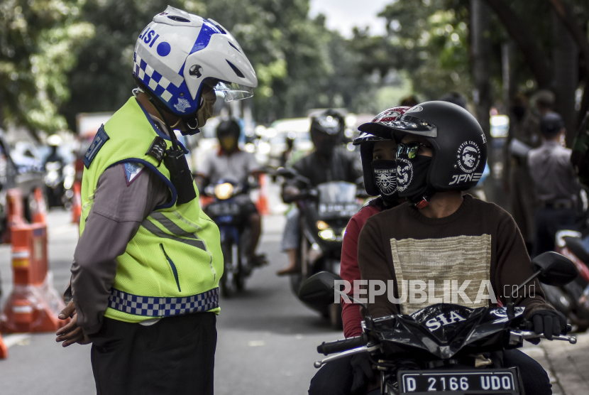 Petugas gabungan memeriksa pengendara di pos pemeriksaan Pembatasan Sosial Berskala Besar (PSBB). Ilustrasi