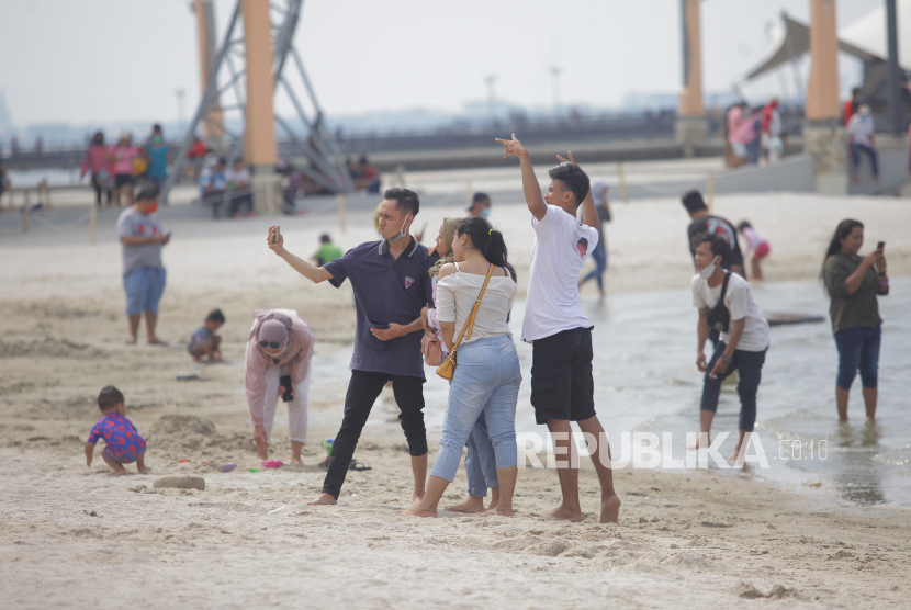 Wisatawan menikmati suasana Pantai Lagoon, Ancol, Jakarta