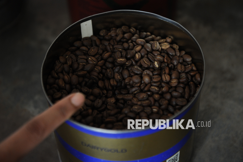 Pekerja menunjuk biji kopi yang akan digiling menjadi kopi di Toko Sedap Djaja Wong Hin, Jatinegara, Jakarta, Rabu (20/8/2025). Pasar kopi arabika global melonjak pada Agustus dengan harga naik lebih dari 30 persen di bursa ICE.