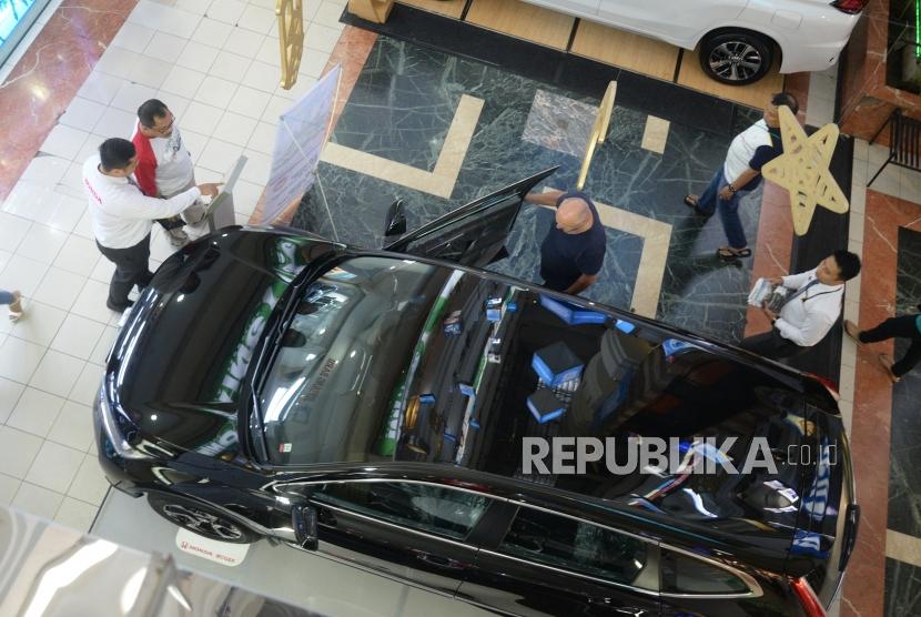 Pegawai menawarkan mobil di pusat perbelanjaan, Jakarta, Ahad (24/6).