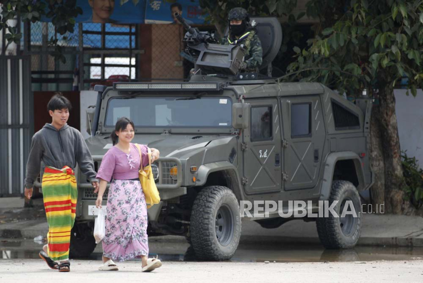 Warga Myanmar berjalan melewati seorang tentara Thailand yang berjaga di kendaraan militer di perbatasan Thailand-Myanmar di distrik Mae Sot, provinsi Tak, Thailand, 12 April 2024.