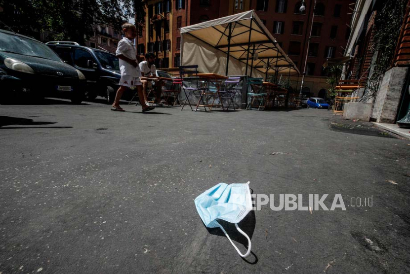 Sebuah masker wajah yang dibuang di jalan raya di Roma, Italia, (26/5). Menurut laporan media, ahli lingkungan memperingatkan bahwa masker dan sarung tangan sekali pakai yang digunakan untuk mencegah penyebaran penyakit coronavirus adalah polutan tambahan yang mengancam lingkungan