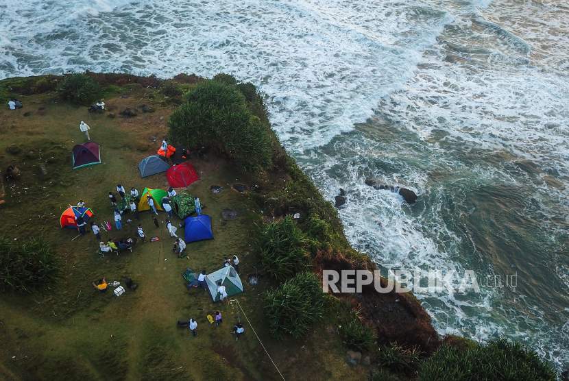 Foto udara wisatawan menggelar tenda di Kawasan Wisata Puncak Guha, Kabupaten Garut
