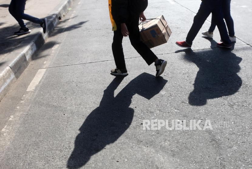 Pemudik berjalan seusai turun dari bus di Terminal Kampung Rambutan, Jakarta, Senin (18/6).