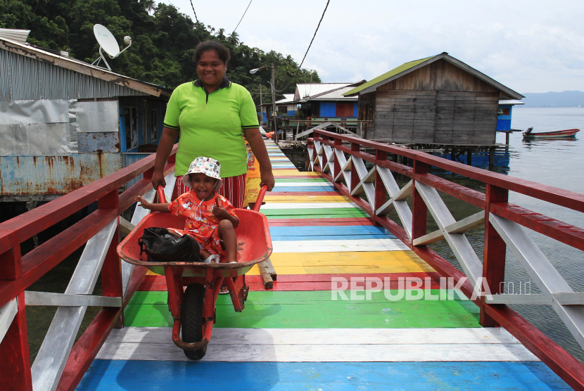 Warga berjalan di sekitar pemukiman kumuh di Kampung Kayo Batu, Kota Jayapura, Papua, Jumat (8/12/2023). Pemerintah Provinsi Papua telah menangani kawasan kumuh sebanyak 92,97 persen dari 100,7 persen luasan kumuh yang tercatat di Kota Jayapura. 