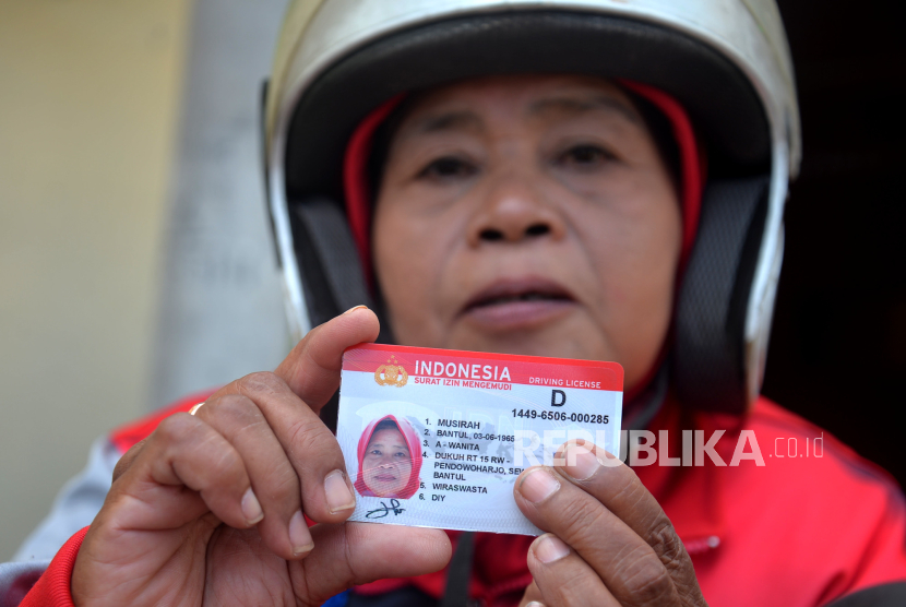 Warga menunjukkan surat izin mengemudi (SIM). 