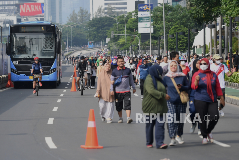 Sejumlah warga melintas di kawasan Bundaran HI Jakarta saat Hari Bebas Kendaraan Bermotor (HBKB) di kawasan tersebut, Ahad (12/6/2022). Warga memanfaatkan HBKB di Jakarta untuk berolahraga seperti bersepeda dan berjalan kaki. 