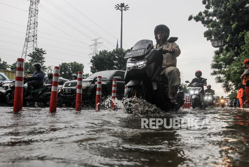 Pengendara motor melewati genangan air di Jalan DI Pandjaitan, Jatinegara, Jakarta Timur, Senin (5/2/2024). Hujan diprakirakan akan mengguyur sebagian wilayah Jakarta, Selasa (6/2/2024).