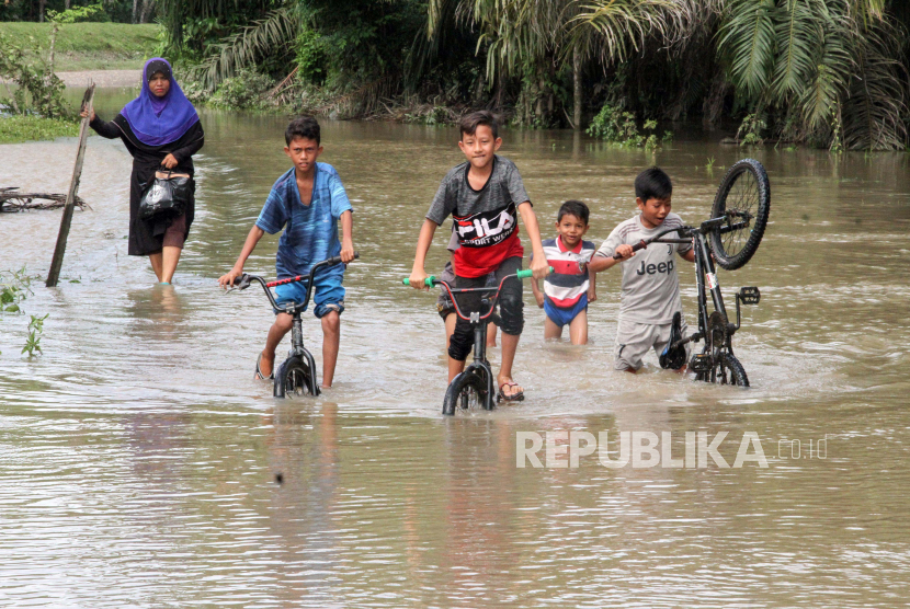 Sejumlah anak bersepeda melintasi banjir di Aceh (ilustrasi)