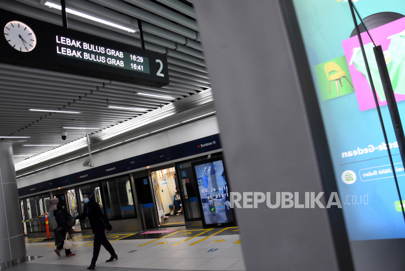 Penumpang menaiki kereta MRT di Stasiun MRT Bundaran HI, Jakarta Pusat, Jumat (18/12/2020).