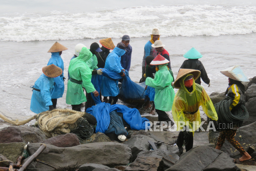 Nelayan bergotong-royong mengangkat jaring berisi ikan di Pantai Timur Pangandaran, Ahad (25/10). (ilustrasi)