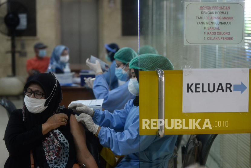 Petugas kesehatan menyuntikkan vaksin Covid-19 kepada warga di sentra vaksinasi Gedung Wira Purusa LVRI DKI Jakarta, Kamis (12/8). Polda Metro Jaya menyebutkan, Jakarta telah mencapai kekebalan kelompok (herd immunity) berdasarkan rujukan 70 persen warga telah divaksin yang ditetapkan oleh Organisasi Kesehatan Dunia atau World Health Organisation (WHO).
