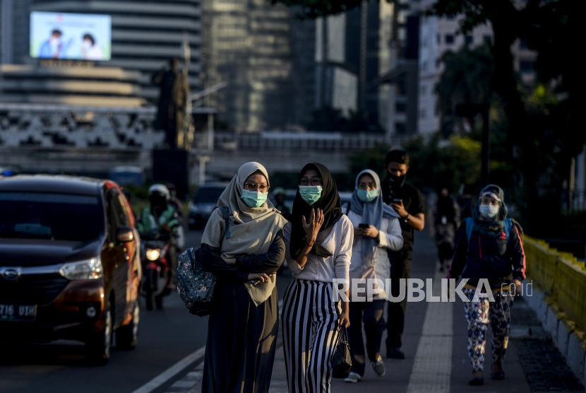 Sejumlah warga menggunakan masker saat berjalan di kawasan Sudirman, Jakarta, Selasa (8/9). Jumlah kasus positif Covid-19 di Tanah Air pada Selasa (8/9) bertambah sebanyak 3.046 kasus baru dan secara akumulasi kasus Covid-19 di Indonesia menembus hingga mencapai angka 200.035 orang.