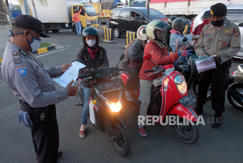 Polisi memeriksa kelengkapan surat pemudik yang datang dari pulau Jawa setibanya mereka di Pelabuhan Gilimanuk, Jembrana, Bali. Seorang komisioner KPU Jembrana, Bali, dinyatakan tertular COVID-19 setelah mengeluh fisiknya letih dan mengalami demam.