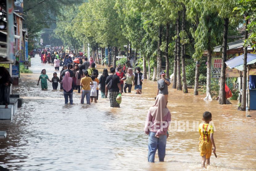 Warga melintasi banjir di Desa Kedawung, Grati, Pasuruan, Jawa Timur, Sabtu (11/2/2023). (Ilustrasi)