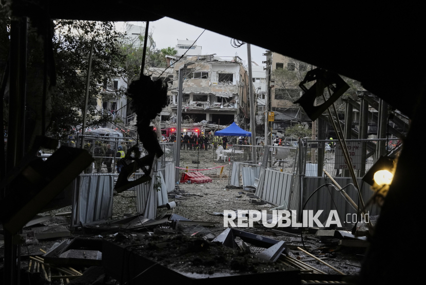 Tim penyelamat bekerja di lokasi di mana rudal yang diluncurkan dari Iran menghantam Tel Aviv, Israel, Senin, 16 Juni 2025.
