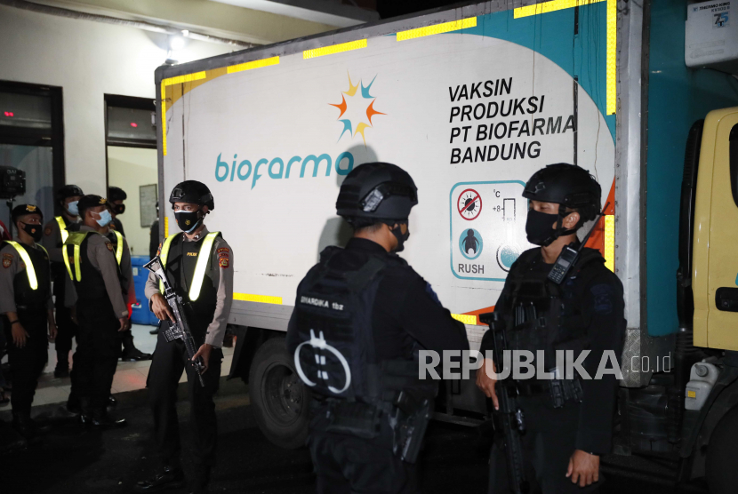  Petugas polisi berjaga-jaga di depan gedung penyimpanan pada saat kedatangan vaksin Covid-19 SinoVac, di Bali, Indonesia, awal 05 Januari 2021. 