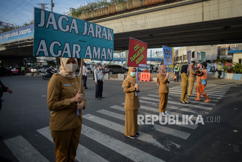 Petugas Kecamatan Senen membawa alat peraga saat kampanye penerapan protokol kesehatan di lampu merah Simpang Lima Senen, Jakarta Pusat, Selasa (9/1). Kampanye tersebut dilakukan sebagai upaya mengajak masyarakat untuk menerapkan protokol kesehatan mengingat kasus positif COVID-19 di Provinsi DKI Jakarta terus mengalami peningkatan.