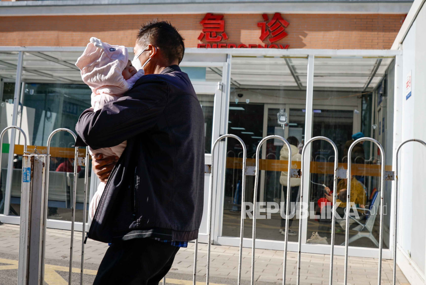 Seorang pria membawa anaknya ke rumah sakit di Cina karena terinfeksi Covid-19. Dinkes Jabar mencatat ada sebanyak 87 warga yang terinfeksi Covis-19 varian baru.