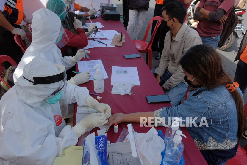 Tim medis melakukan tes cepat COVID-19 terhadap warga dalam penerapan Pembatasan Kegiatan Masyarakat (PKM) di pos pantau perbatasan Penatih, Denpasar, Bali, Sabtu (16/5/2020). 