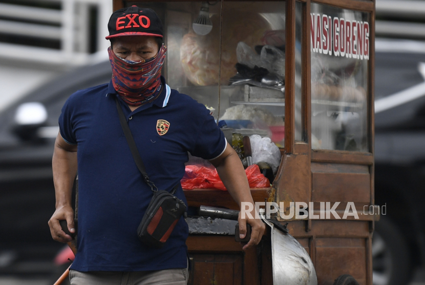 Pedagang nasi goreng beraktivitas saat pandemi virus corona di Jakarta. DKI diminta segera mengeksekusi status Pembatasan Sosial Berskala Besar (PSBB) untuk percepatan penanganan Covid-19. 