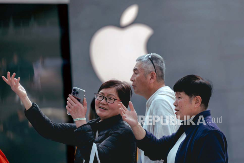 People stand in front of the Asian largest Apple store, in Shanghai, China, 22 March 2024. The largest Apple store in Asia, located in Shanghai, officially opened on 21 March 2024. Reports indicate that the Shanghai Jing