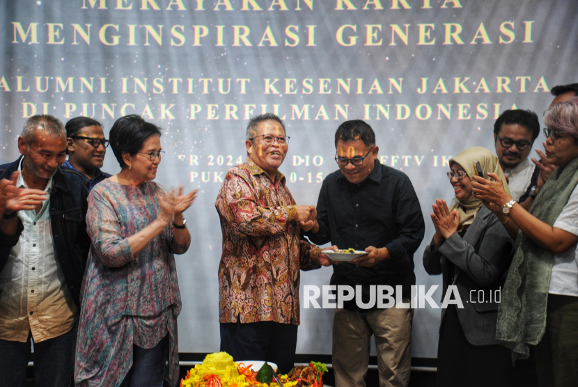 Rektor Institut Kesenian Jakarta (IKJ) Syamsul Maarif memberikan potongan tumpeng kepada Alumni IKJ yang juga Sutradara Garin Nugroho saat acara apresiasi dan penghargaan kepada alumni IKJ yang menorehkan prestasi di dunia perfilman Indonesia dan Internasional di Studio Tom Kampus IKJ, Rabu (11/12/2024). Kegiatan pemberian apresiasi dan penghargaan kali ini mengangkat tema besar Merayakan Karya, Menginspirasi Generasi: Alumni Institut Kesenian Jakarta (IKJ) di Puncak Perfilman Indonesia. Di Tahun 2024 hingga kedepan, IKJ berkomitmen akan meningkatkan peran dan keterlibatan alumni secara optimal dalam setiap pengembangan kelembagaan dan program kerja, momen ini merupakan awal dari kerja sama yang akan dilakukan Alumni bersama IKJ untuk Bertransformasi Menuju IKJ Unggul.