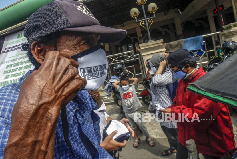 Pengemudi becak memakai masker yang diberikan oleh perwakilan wartawan di Citeureup, Bogor, Jawa Barat.  Pemerintah Kabupaten Bogor, Jawa Barat, mengumumkan kembali adanya satu pasien COVID-19 yang sembuh sehingga jumlahnya secara keseluruhan menjadi 23 orang.