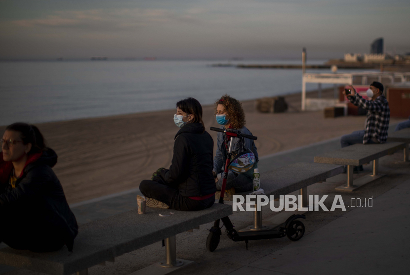 Sejumlah orang duduk di kursi pinggir laut di Barcelona, Spanyol, Ahad (3/5). Warga Spanyol memenuhi jalan-jalan kota untuk melakukan olahraga setelah tujuh minggu mengalami lockdown sebagai upaya melawan Covid-19