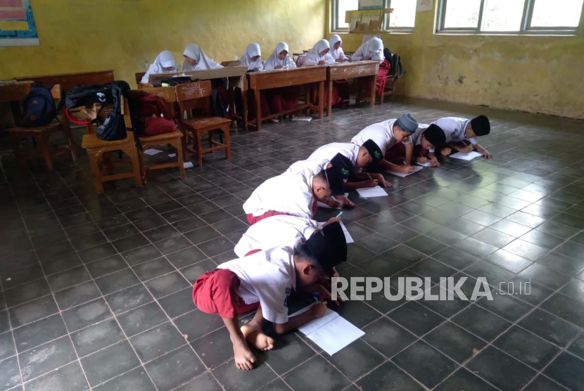 Siswa di SDN Temanggung, Kecamatan Bojongasih, Kabupaten Tasikmalaya, belajar tanpa menggunakan meja dan kursi. 
