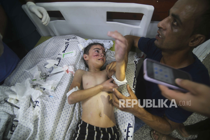 A Palestinian child wounded in Israeli bombardment waits for treatment in a hospital in Rafah refugee camp, southern Gaza Strip, Thursday, Oct. 12, 2023.  