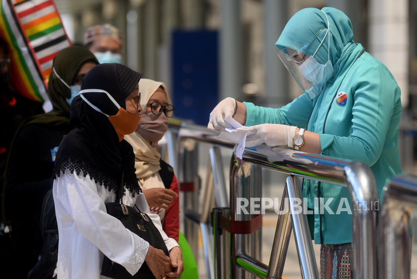 Petugas memeriksa  kelengkapan penumpang sebelum memasuki area peron di Stasiun Pasar Senen, Jakarta Pusat.