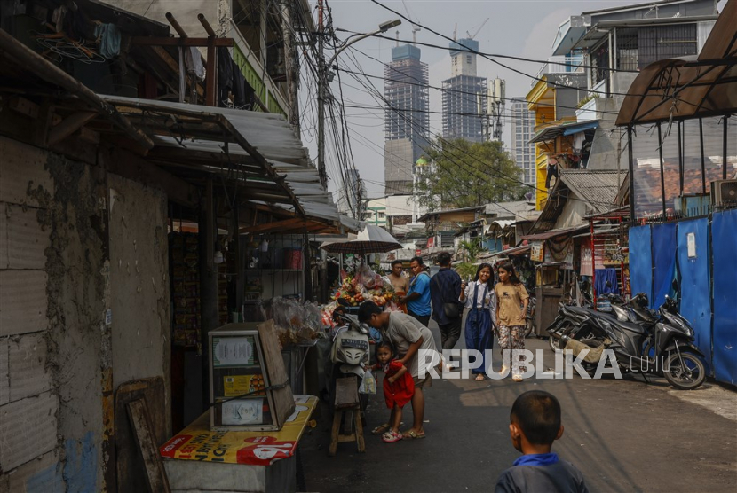Orang-orang berkumpul di jalan di daerah kumuh Jakarta.