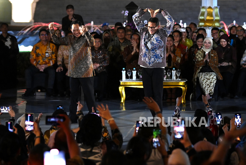 Mendagri Tito Karnavian (kiri) dan Menparekraf Sandiaga Uno dengan busana batik bergaya di atas catwalk dalam acara Istana Berbatik di depan Istana Merdeka, Jakarta, (1/10/2023). 