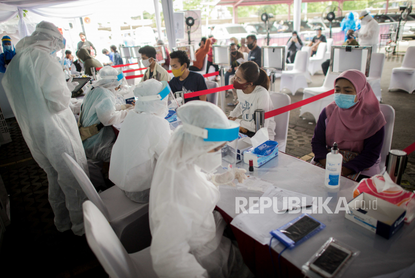 Petugas Medis mengambil sampel darah warga saat rapid test massal di Depok, Jawa Barat, Jumat (22/5).
